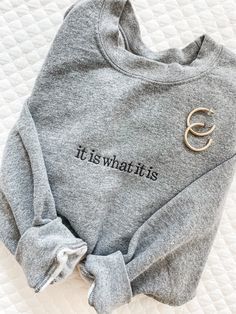 "Our IT IS WHAT IT IS Sweatshirt is going to be your new closet favorite. With so many colors to choose from and at such a great price, you can buy one for your BFF as well!! These are unisex sizing. Sample shown in Graphite Heather and Black thread. 8-ounce, 50/50 cotton/poly Double-needle stitching at waistband and cuffs 1x1 rib knit collar, cuffs and waistband with spandex **NOT PROVIDING ALL OF THE REQUIRED INFORMATION FOR PERSONALIZATION WILL DELAY YOUR ORDER.** When checking out, put this New Closet, Black Thread, Embroidered Sweatshirt, Loungewear Sets, Embroidered Sweatshirts, Fall Shopping, Health Awareness, Mental Health Awareness, New Moms