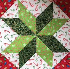 a green and white star on a red table cloth with candy canes around it