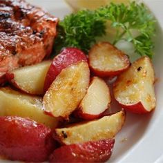 a white plate topped with meat and potatoes