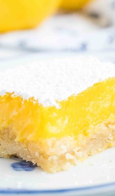 a close up of a piece of cake on a plate with lemons in the background