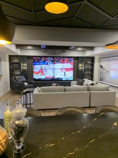 a living room filled with furniture and a flat screen tv mounted to the wall above it