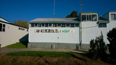 a building with a sign on the side of it that says scout and people are hanging out front