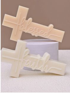 two soap bars with the word faith spelled in white frosting on top of each other