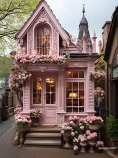 a pink house with lots of flowers on the outside