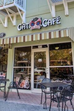 the outside of a cafe with tables and chairs