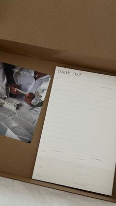 an open box containing papers and wine glasses