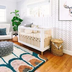 a baby's room with a white crib and blue rug