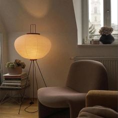 a lamp that is sitting on top of a floor next to a chair and table