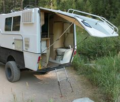 an rv parked on the side of a road with its door open and it's seat up