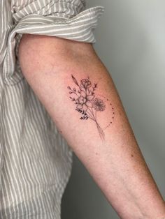 a woman's arm with a flower tattoo on the left side of her arm