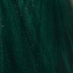 a woman wearing a green dress with glitters on it