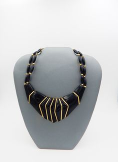 Structural jewelry are classic pieces. Their artistic appeal transcends all decades. Napier had a flair for designing pieces of wearable art. Even in the 1990s, when this piece was manufactured, time has strengthen its appeal and beauty. Jet black hard resin, with sharp lines of geometrical shapes, form the backbone of the necklace. Bold gold-plated angled pieces separate and define the black resin. Trailing from the hardness of the statement, are black oblong beads, each separated by small gold Vintage Jewelry With Unique Design For Formal Occasions, Vintage Formal Jewelry With Unique Design, Black Metal Jewelry With Unique Design, Unique Design Black Metal Jewelry, Structural Jewelry, Ice Necklace, Napier Jewelry, Geometrical Shapes, Black Resin