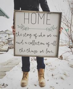 a person standing in the snow holding a sign that says, home there is no one and a collection of all the things we love