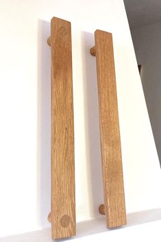 two wooden door handles on a white wall