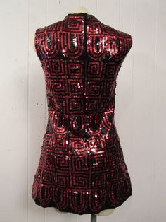 "Vintage 1960s mini dress with black and red sequins. Geometric design. Sleeveless. Neru collar, back zipper and Satin lining. Made by Winkleman's. Size small/medium. Actual measurements are: 33\" around the bust 31\" around the waist 33\" around the hips 14\" shoulder to shoulder 30\" overall length In excellent condition." Red Sequined Flapper Dress For Party, Retro Sleeveless Mini Dress For Evening, Vintage Mini Dress For Party Season Night Out, Red Vintage Mini Dress For Party, Vintage Mini Dress For Night Out During Party Season, Fitted Red Flapper Dress With Sequins, Fitted Red Sequin Flapper Dress, Red Fitted Flapper Dress For Parties, Red Sequined Flapper Dress For Evening