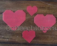 three pink heart shaped iron - on patches sitting on top of a wooden table