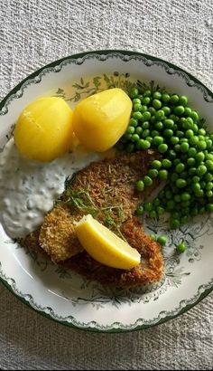 a white plate topped with fried fish and peas