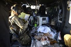 a soldier is sitting in the back of an aircraft with supplies on it and reading