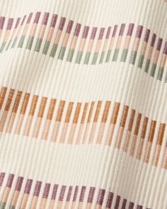 closeup of an upholstered fabric with multicolored lines on it,