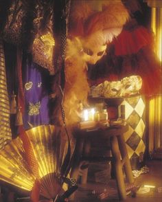 an assortment of decorative items displayed on a table with candles and fan in the foreground