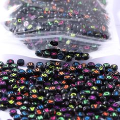 black beads with multicolored letters in plastic bags