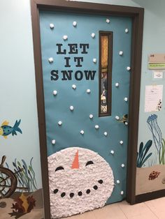 a door decorated to look like a snowman with the words let it snow on it