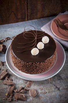 a chocolate cake sitting on top of a table next to plates and utensils