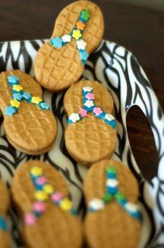 some cookies are on a zebra print plate with colorful sprinkles around them