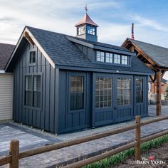 a small blue building with a clock tower on the top of it's roof