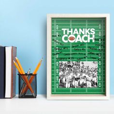 a green poster with the words thanks coach on it next to books and pencils