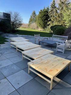 several wooden benches sitting on top of a stone patio