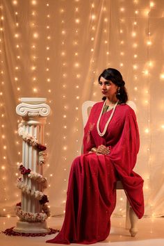 Reminiscent of the Bollywood divas of 1950s, the sarees in this collection aim at re living that timeless & elegant era, that is so close to the timelessness of Mukaish Embroidery. This Wine Coloured Saree is adorned with delicate embroidery of Flight of Pigeons (original Meiraas motif) on palla in a triangle flight pattern, while rest of the saree is covered with stars of Mukaish. NOTE: Mukaish is a Heritage Embroidery done by hand. This embroidery was initially done with Gold & Silver wires ones, but now is done with copper or even brass metal wires polished to gold & silver colour. For this embroidery following steps are taken: 1.)The wires are beaten to a thin thread like consistency first. 2.)A special Mukaish needle uses the beaten wires to make intricate patterns that are block prin Eid Celebration Pre-draped Saree With Zari Weaving, Pre-draped Saree With Cutdana For Eid, Traditional Pre-draped Saree For Festive Party, Elegant Pre-draped Saree With Chikankari For Festive Occasions, Navratri Celebration Dola Silk Pre-draped Saree, Navratri Celebration Pre-draped Dola Silk Saree, Bollywood Style Pre-draped Saree For Wedding Festivities, Festive Semi-stitched Pre-draped Saree For Puja, Semi-stitched Traditional Wear For Celebration