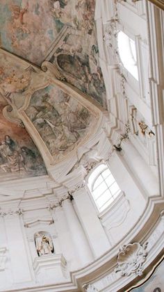 the ceiling of an old building with paintings on it