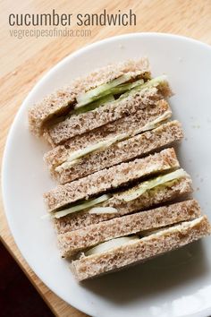 four sandwiches stacked on top of each other on a white plate with the words cucumber sandwich