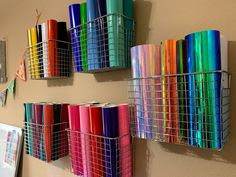 several different colored rolls of tape are on the wall next to each other in baskets