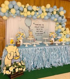 a winnie the pooh themed birthday party with balloons and desserts on a table