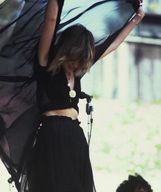 a woman holding an umbrella on top of a stage