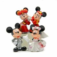 three figurines of mickey and minnie mouse on top of each other in wedding attire