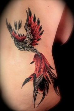 a woman's stomach with a bird tattoo on the side, and feathers coming out of it