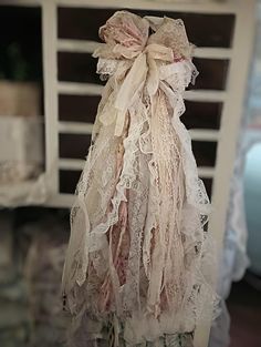 the doll is wearing a white dress with lace on it