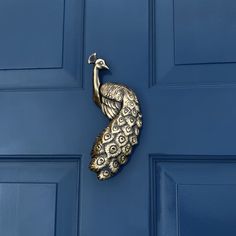 a peacock door knocker on a blue front door