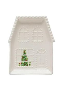 a small white house shaped dish with christmas decorations on the front and side, decorated in green