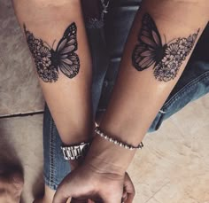 two people holding hands with butterfly tattoos on their arms, both wearing matching bracelets