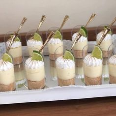 small desserts are lined up on a tray with gold spoons and garnishes