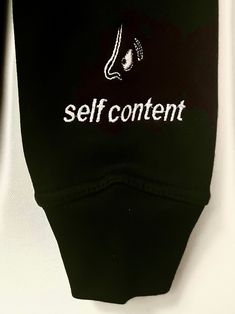 Heavy, black 100% cotton hoodie with white embroidery. Back panel: “For Me” in the center with page 2 indicated at the bottom. Left arm: “Self Content” across left wrist, with A Shot in the Dark logo above. Fit: Slim fitting body, recommend to size up one size for natural fit, two sizes for oversized fit | Model is wearing size small Care Instructions: Machine wash cold or dry clean Dark Logo, Shot In The Dark, Idea Board, White Embroidery, Cotton Hoodie, In The Dark, Fitness Models, Care Instructions, Dry Clean