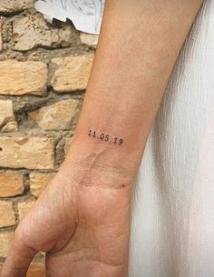 a person with a small wrist tattoo on their left arm and the date 1911 in black ink