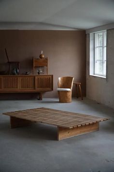 an empty room with a wooden table and chair