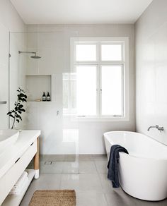 a large white bathroom with a tub and sink