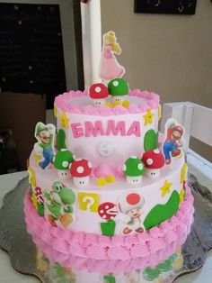 a pink and white cake decorated with cartoon characters