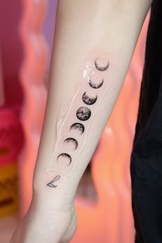 a woman's arm with phases of the moon on it